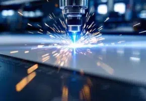 Precisielaser snijdt door wit PVC-materiaal met blauwe lichtstraal en vonken op industriële snijdtafel