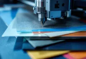 Precisie plotter snijdt door gestapelde materialen zoals vinyl, leer en plastic met scherp mes onder studiobelichting