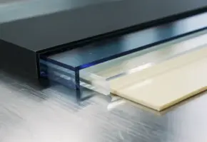Precisiegesneden kunststofplaten van acryl, PVC en polycarbonaat in waaiervorm op stalen werkoppervlak.