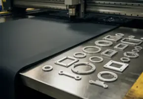 Industriële rubberplaat half gestanst tot geometrische componenten op stalen werktafel, close-up met scherpe schaduwen.