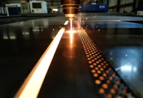 Laserstraal die een metalen plaat doorsnijdt met twee snijpatronen: een vloeiende groef en een gestippeld pulsspoor, gloeiende oranje hitte zichtbaar.