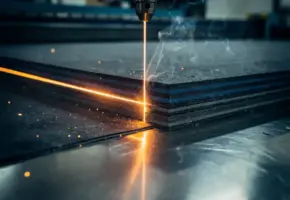 Laserstraal snijdt nauwkeurig door gestapelde lagen rubber, vilt en plastic op een stalen snijttafel, met fijne rookwisps langs de snijkant.