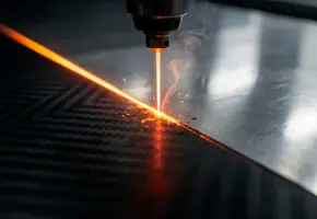 Laserstraal snijdt nauwkeurig door geweven koolstofvezelplaat met oranje gloeiende snijlijn en opstijgende rookslierten.