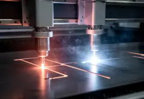 Twee lasersnijkoppen boven donker metaalplaat, één met oranje gloed en één met intens blauw-wit laserlicht, rookwisps stijgen op uit precisiesnijtlijnen.