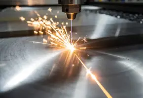 Laserstraal snijdt precies door gepolijst titaniumplaat met gloeiende oranje-witte snijlijn en vonkenregen in industriële werkplaats.