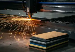Precisielasermachine snijdt door dik staalplaat met oranje vonkenregen, materiaalstalen van rubber, plastic en vilt op achtergrond.